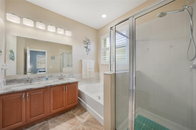 bathroom with double vanity, a bath, a stall shower, and a sink