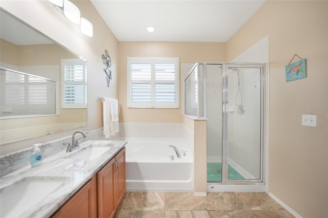 bathroom featuring a shower stall, a garden tub, double vanity, and a sink