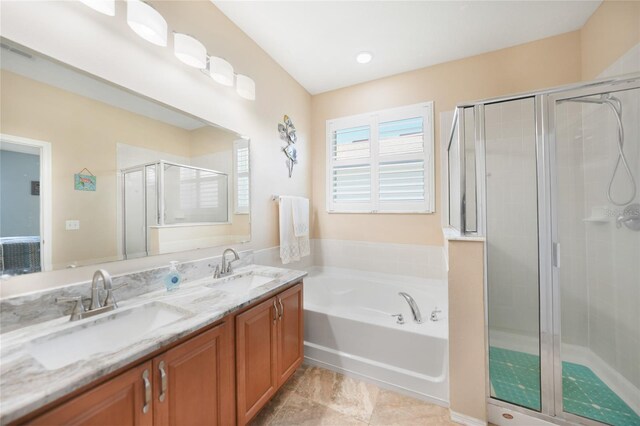 full bathroom featuring a bath, a stall shower, double vanity, and a sink