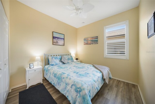 bedroom with a ceiling fan, wood finished floors, and baseboards