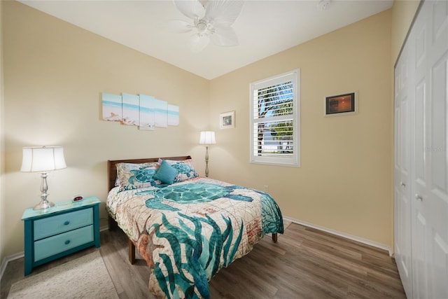 bedroom featuring a ceiling fan, wood finished floors, a closet, and baseboards