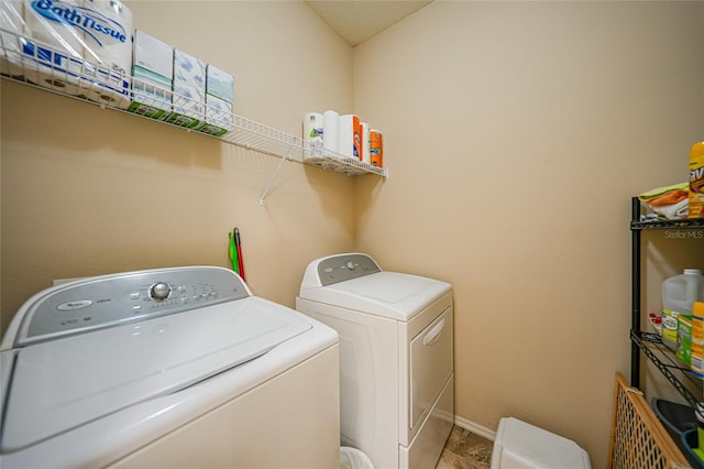 clothes washing area featuring laundry area, washing machine and dryer, and baseboards