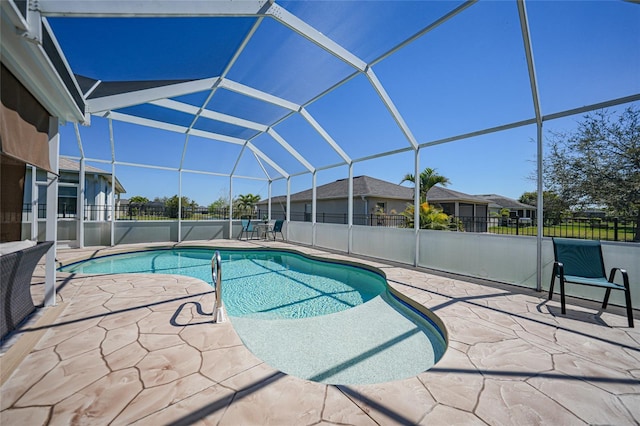 view of swimming pool featuring glass enclosure, a patio area, and fence