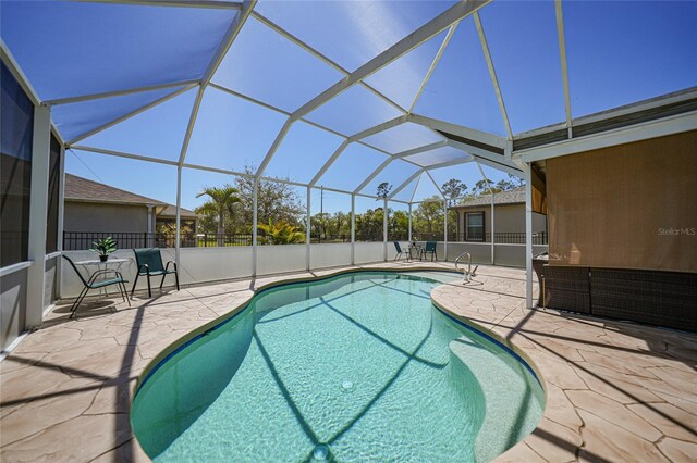 view of pool with a fenced in pool, a patio, and glass enclosure