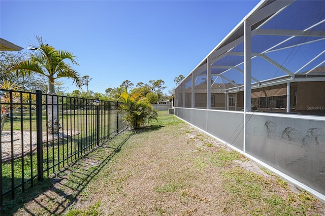 view of yard featuring glass enclosure and a fenced backyard