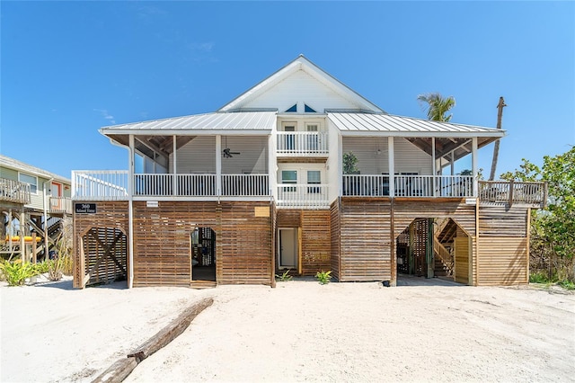 view of front facade featuring a carport, stairway, a ceiling fan, and metal roof