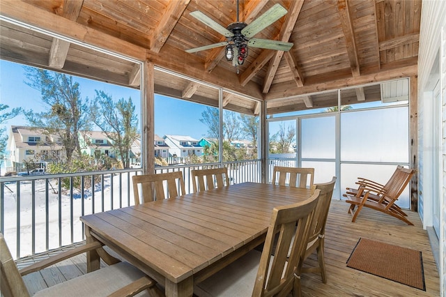 sunroom featuring wooden ceiling, vaulted ceiling with beams, a ceiling fan, and a residential view