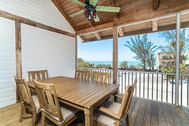 wooden deck featuring outdoor dining space, a ceiling fan, and a water view