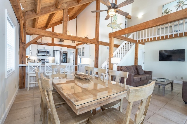 dining room with light tile patterned floors, beam ceiling, ceiling fan, stairs, and wood ceiling