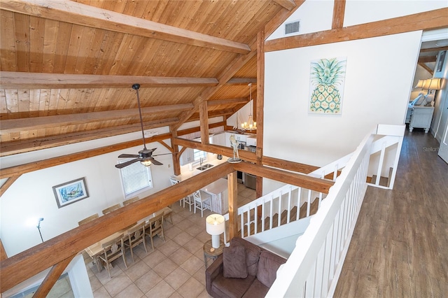 living area with lofted ceiling with beams, visible vents, wooden ceiling, and ceiling fan with notable chandelier