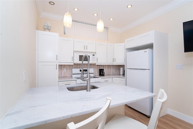 kitchen with white cabinets, white appliances, a breakfast bar, and crown molding