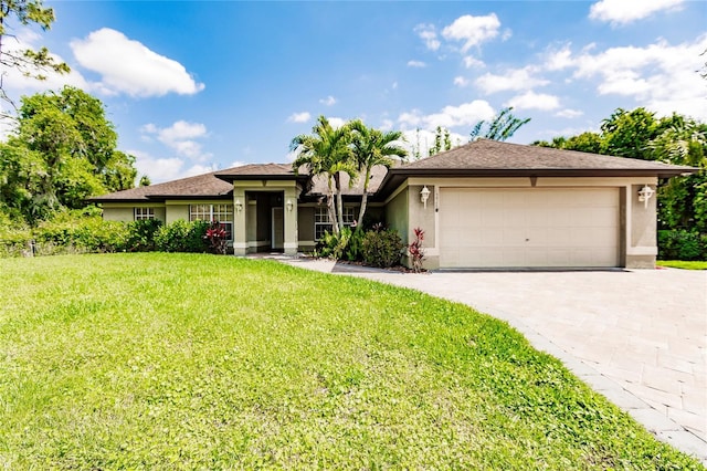 prairie-style house with stucco siding, decorative driveway, a front lawn, and an attached garage