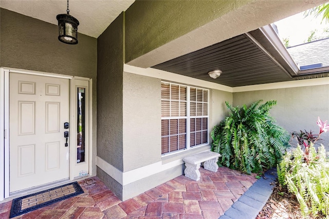 entrance to property featuring stucco siding