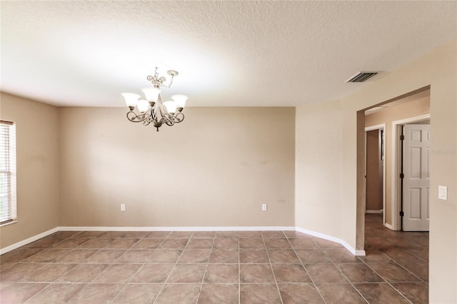 unfurnished room with visible vents, baseboards, a chandelier, tile patterned floors, and a textured ceiling