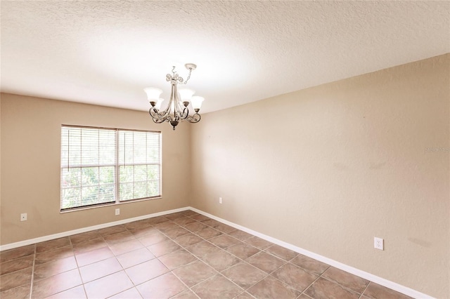 unfurnished room featuring light tile patterned flooring, a notable chandelier, a textured ceiling, and baseboards