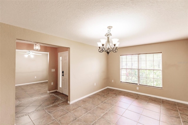 unfurnished room featuring tile patterned flooring, ceiling fan with notable chandelier, a textured ceiling, and baseboards