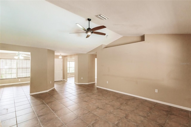 spare room featuring tile patterned flooring, visible vents, baseboards, ceiling fan, and vaulted ceiling