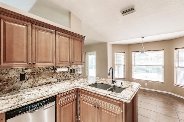 kitchen with visible vents, light stone countertops, a peninsula, stainless steel dishwasher, and a sink