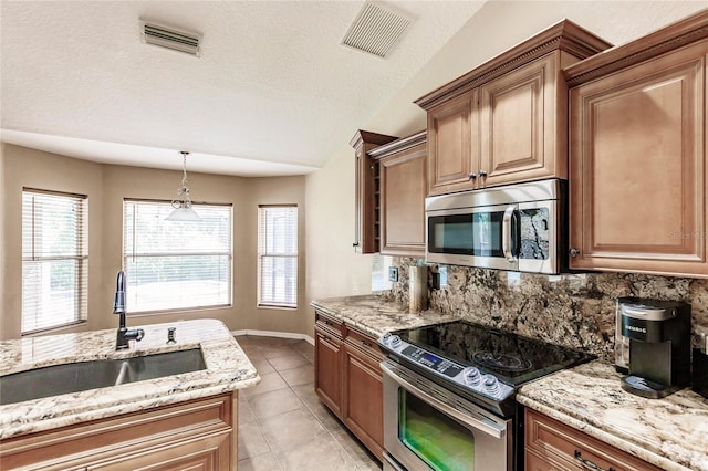 kitchen with a sink, decorative backsplash, visible vents, and stainless steel appliances