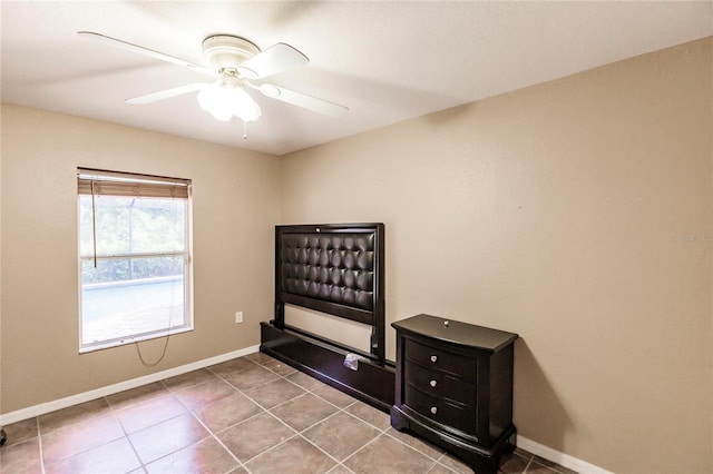 unfurnished bedroom with tile patterned floors, baseboards, and a ceiling fan