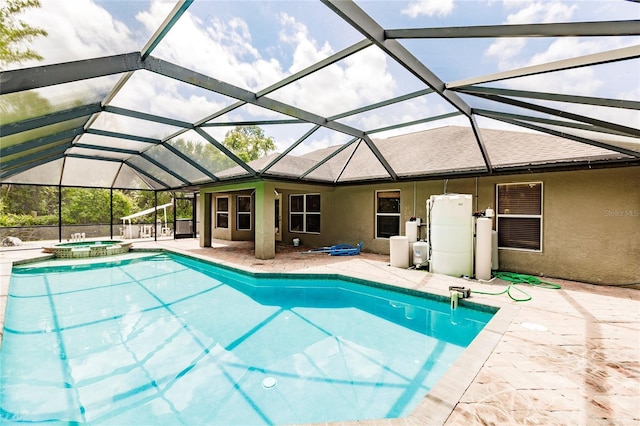 view of pool with glass enclosure, a pool with connected hot tub, and a patio area