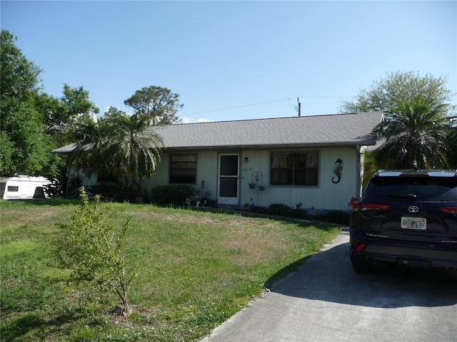 single story home with a front yard and a shingled roof