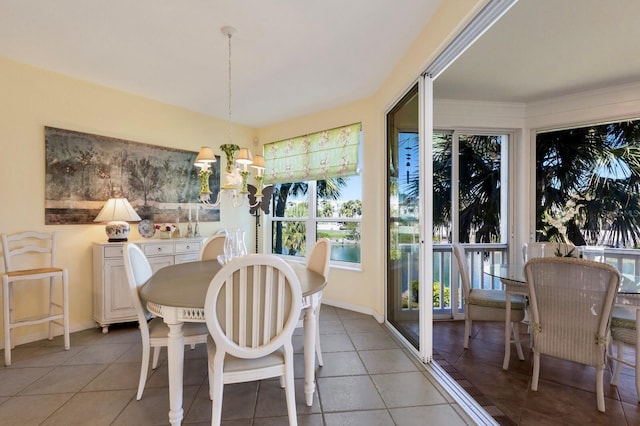 dining space featuring light tile patterned flooring, baseboards, and a chandelier