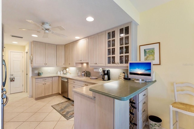 kitchen featuring glass insert cabinets, a peninsula, light tile patterned flooring, a ceiling fan, and stainless steel dishwasher