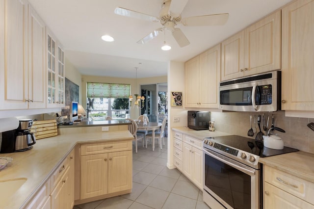 kitchen featuring light brown cabinetry, backsplash, appliances with stainless steel finishes, and a peninsula