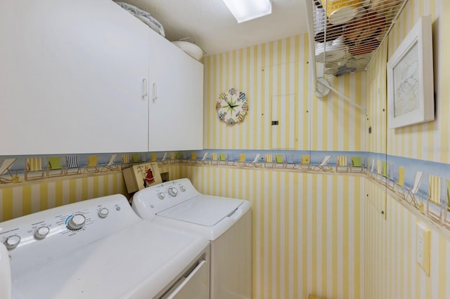 washroom with washer and dryer, cabinet space, and wallpapered walls