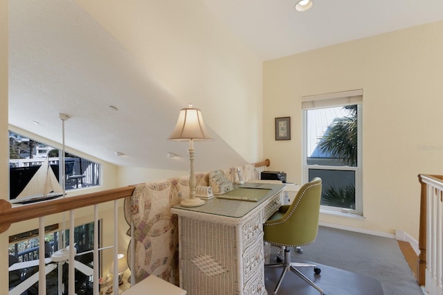 carpeted office space with baseboards and lofted ceiling