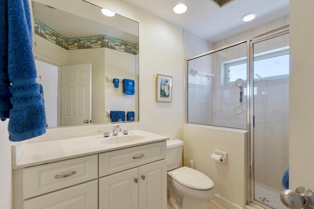 bathroom featuring vanity, toilet, and a stall shower