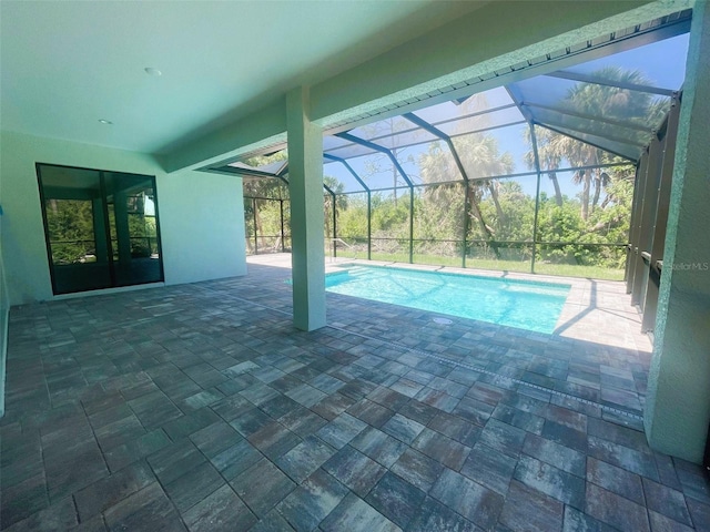 pool with a patio and glass enclosure