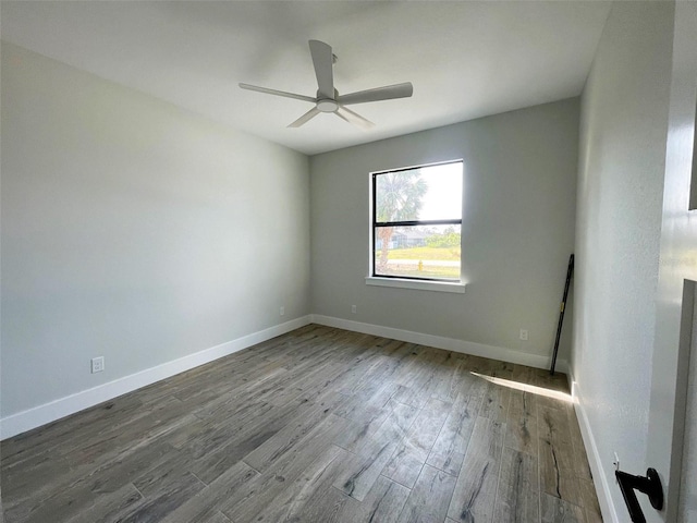 unfurnished room featuring wood finished floors, baseboards, and a ceiling fan