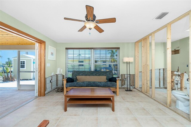 living room with light tile patterned flooring, visible vents, a healthy amount of sunlight, and ceiling fan