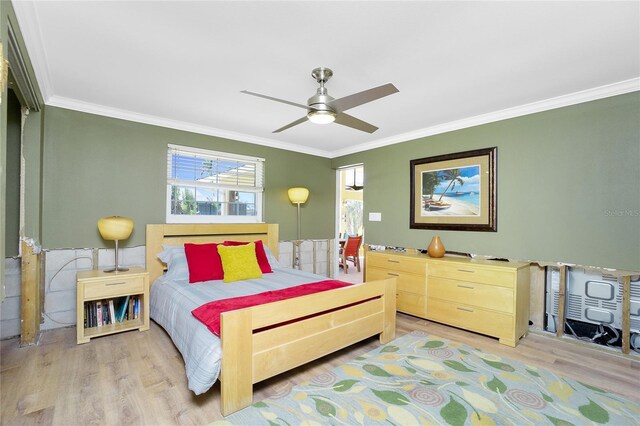 bedroom featuring ornamental molding and light wood finished floors