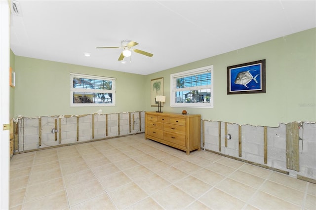 empty room with light tile patterned flooring, visible vents, and a ceiling fan