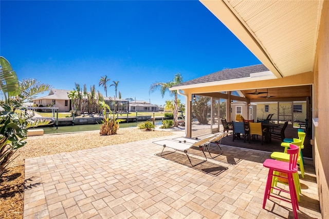 view of patio with outdoor dining space, a ceiling fan, and a residential view