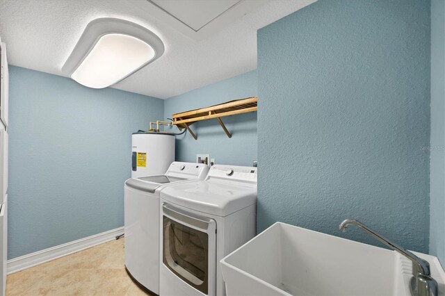 5000 Gasparilla Rd Unit 41B, Boca Grande, FL 33921 - washroom featuring water heater, separate washer and dryer, baseboards, a textured wall, and light tile patterned floors