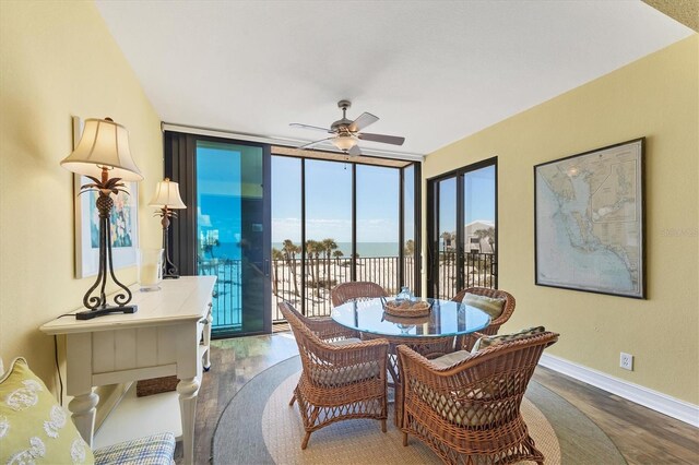 5000 Gasparilla Rd Unit 41B, Boca Grande, FL 33921 - dining room with a wall of windows, wood finished floors, ceiling fan, baseboards, and a water view