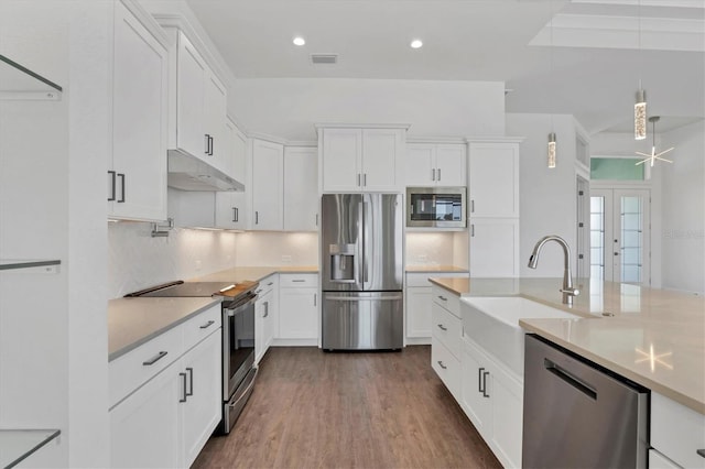 kitchen featuring under cabinet range hood, light countertops, a sink, and appliances with stainless steel finishes