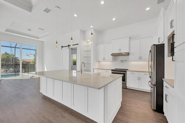 kitchen with a sink, white cabinetry, under cabinet range hood, stainless steel appliances, and visible vents