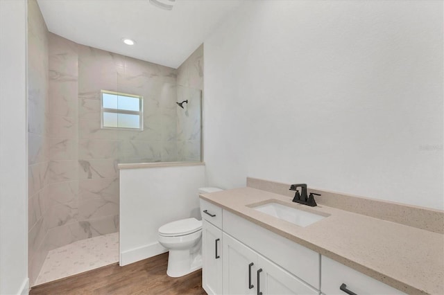 full bathroom with toilet, a walk in shower, vanity, wood finished floors, and recessed lighting