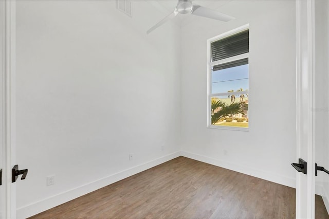 empty room featuring baseboards, wood finished floors, and ceiling fan