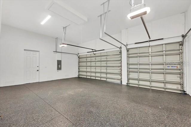 garage with a garage door opener and electric panel