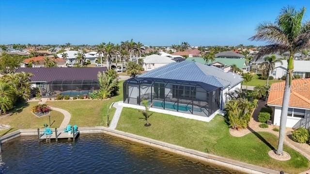 dock area with glass enclosure, a water view, a yard, and a residential view