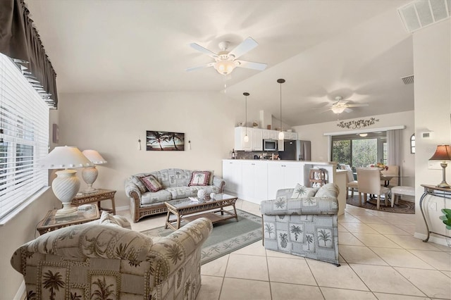 living area featuring ceiling fan, visible vents, vaulted ceiling, and light tile patterned floors