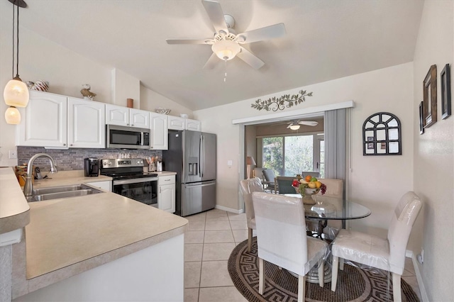 kitchen featuring decorative backsplash, light countertops, a ceiling fan, appliances with stainless steel finishes, and a sink