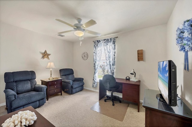 office space featuring a ceiling fan, baseboards, and light colored carpet