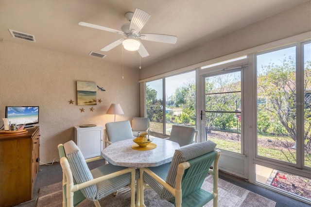 dining space featuring a textured wall, ceiling fan, and visible vents
